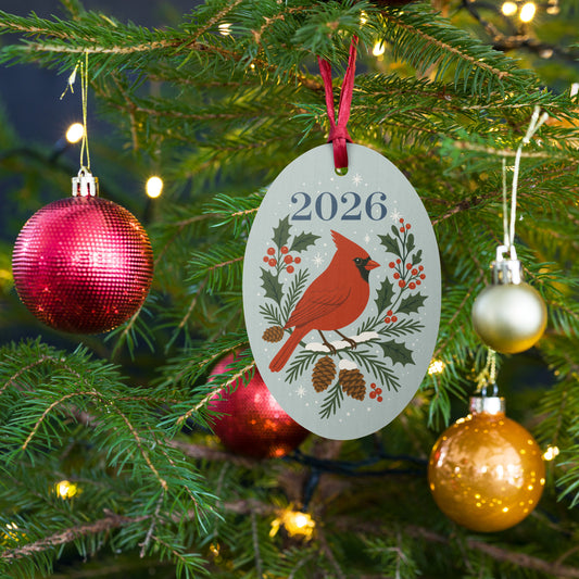 Cardinal wooden ornament hanging on a Christmas tree with festive baubles